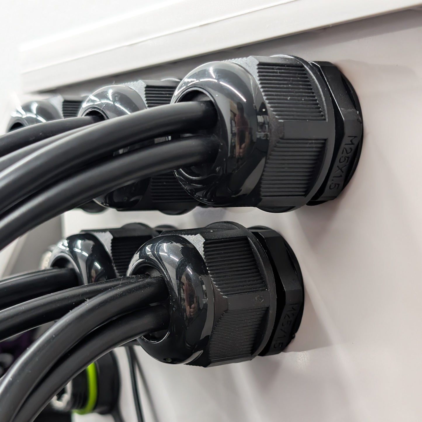 25mm black multi-hole cable glands securing multiple cables in a weatherproof controller enclosure