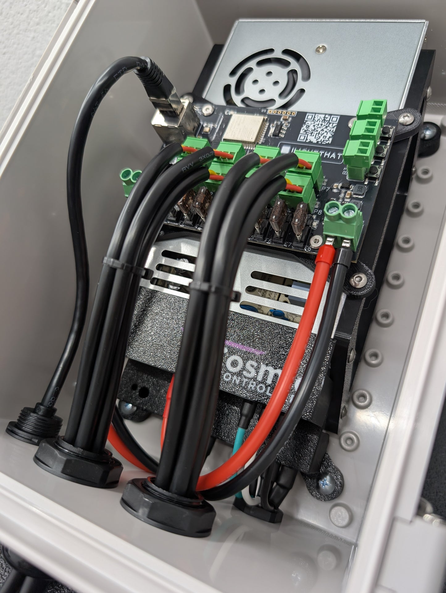 Inside of waterproof enclosure containing two power supplies, wiring, and a Baldrick8 pixel controller.