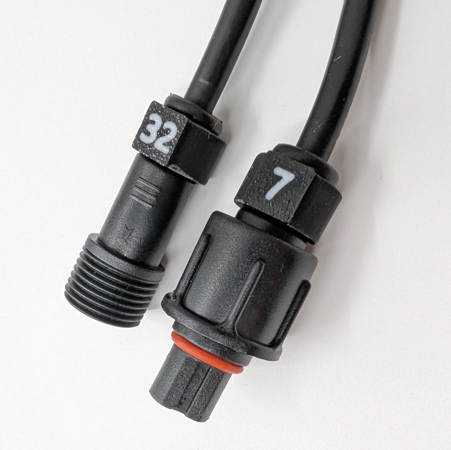 Close-up of black cable ID clips with white numbers installed on the connector of a pigtail wire