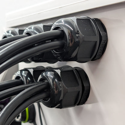 25mm black multi-hole cable glands securing multiple cables in a weatherproof controller enclosure