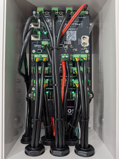 Close up of Baldrick17 board mounted inside grey plastic enclosure with red and black power wires running to it.