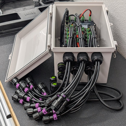 View of Cosmic Pro-Series Baldrick17 pixel controller mounted inside Boxco enclosure with black cables protruding. 