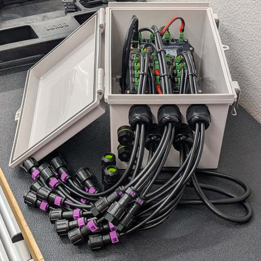 Angled close up view of Cosmic Pro-Series enclosure with lid open sitting on a work bench exposing the neatly wired interior.