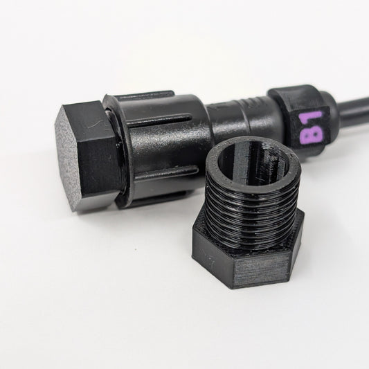 Black male xConnect plug in front of a capped pigtail wire on a white background