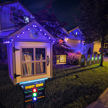 Illuminated Cosmic Launch Control button station beside a Halloween pixel light display.